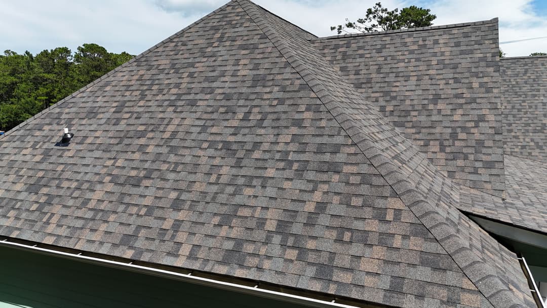 New asphalt shingle roof with gray and brown tones on a residential home.